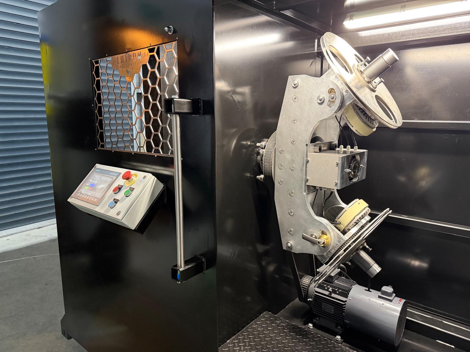 Inside the tangential taping machine — Siemens HMI panel and Lutrom-branded mesh over the precision tangential tape head